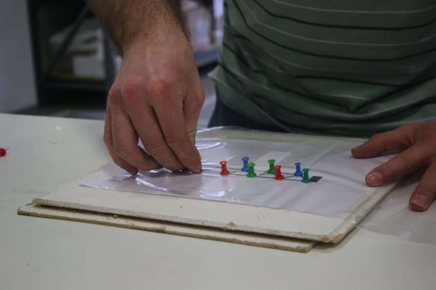 Inserting pushpins into ceiling tile