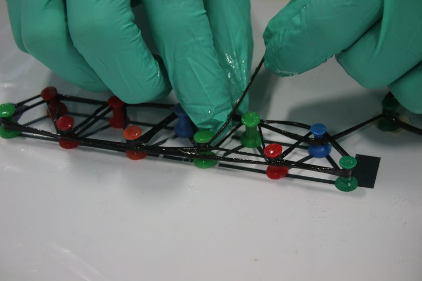 Winding wet-out carbon fiber around pushpins