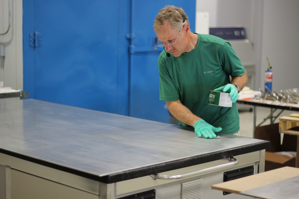 Senior Tech Advisor Tom Pawlak prepares an aluminum surface for epoxy by applying a coat of PARTALL Paste Wax #2, a mold release agent.