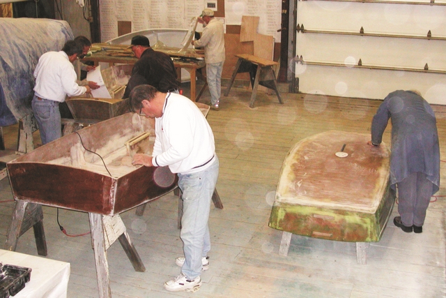 Members of the SBCSA boatbuilding class raise a little dust while finishing new Optimist prams in the Gougeon boatshop.