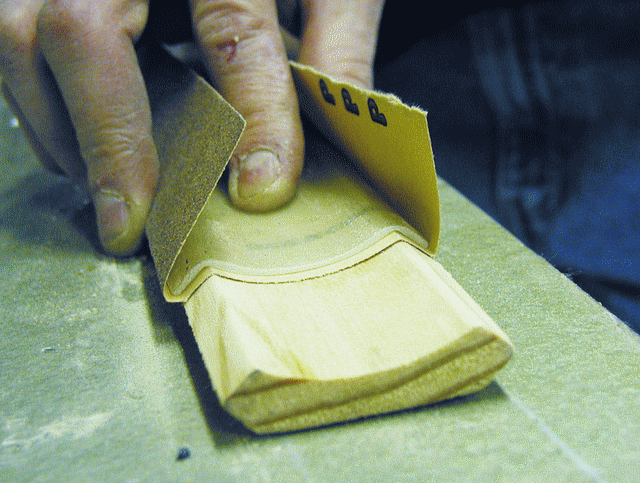 4. Hold the sandpaper under the pad with double-sided tape or feathering disk adhesive. Bond a shaped wooden handle to the back of the pad with G/5, if desired.