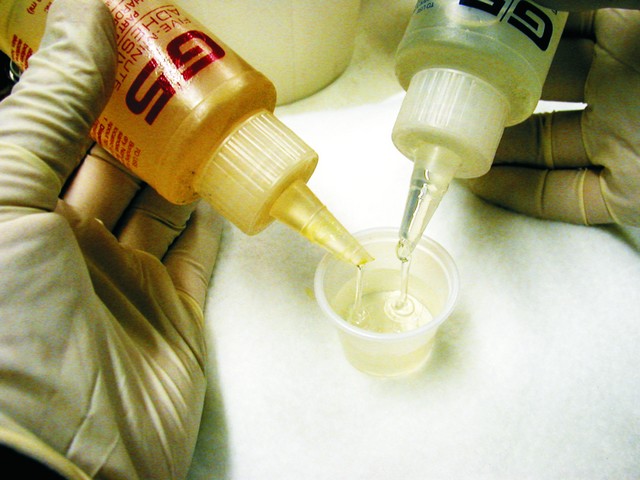 He simultaneously dispensed the resin and hardener into opposite sides of each cup. Although the resin and hardener lay against each other, no reaction occurred until the contents were stirred together.