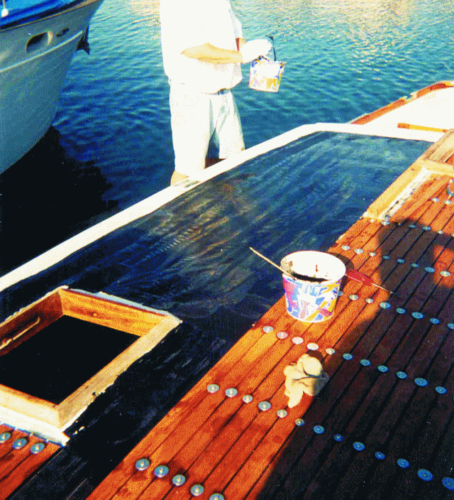 Steve applying the WEST SYSTEM Epoxy/404 High-Density filler/graphite blend prior to placing the teak planks.