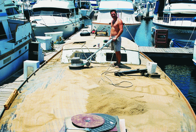 Steve working very diligently on a VERY calm summer day as he sands away more than 160 pounds of teak, epoxy and filler to achieve the smoothest finish.