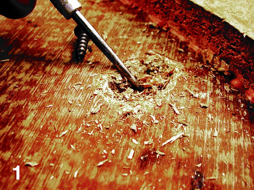 Dig loose wood debris out of the particleboard