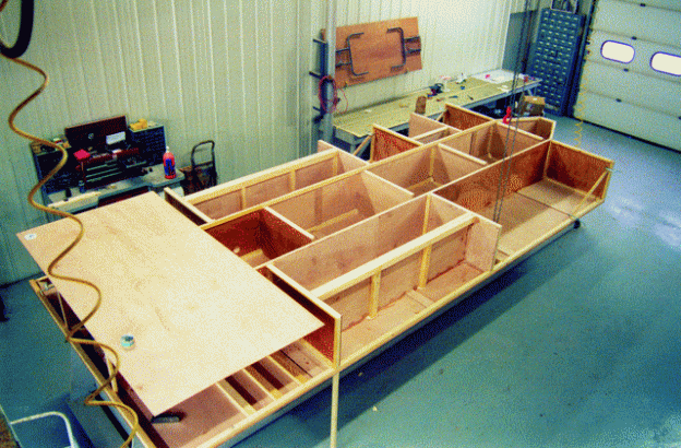 Shown upside down, the base of the trailer is a series of plywood torsion boxes, doubling as storage compartments. The depth of the boxes makes a very light weight, rigid structure.