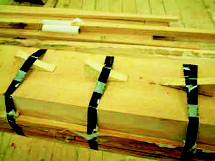 A 2" x 8" x 24' cap was clamped with metal banding tightened by driving wedges under the bands.