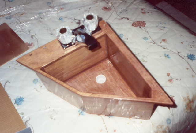 A custom-shaped sink fits a tight spot in the head of FIfty Plus. The seams of the plywood sink are joined with fillets and it is encapsulated in epoxy.