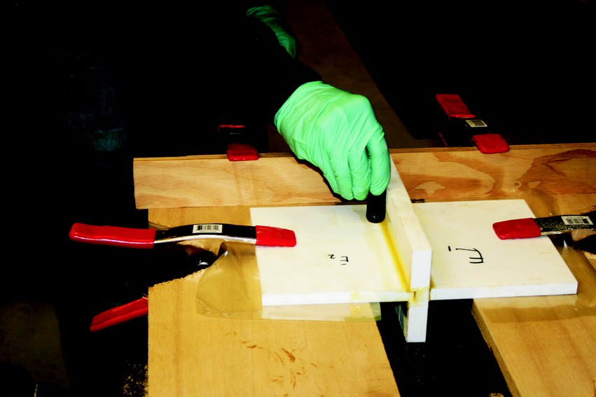 Making a fillet on the test sample billet of polyethylene plastic. Fillets are used to increase the surface area of the joint when gluing plastics.