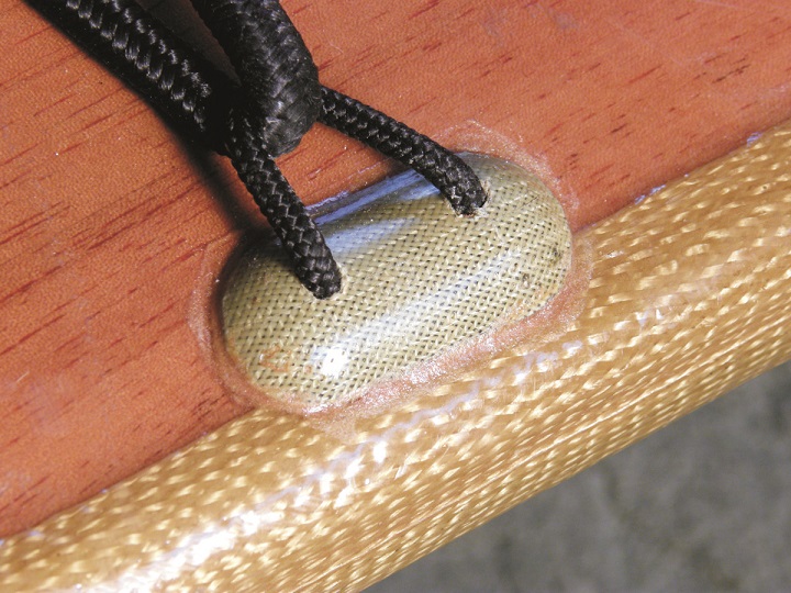 Close up of a soft pad eye mounted to the deck of a Bufflehead. The pad eyes Hugh Horton used on the Bufflehead deck were made with Twaron™ an aramid fiber. The soft pad eyes are strong yet not as likely as rigid pad eyes to catch a knuckle or a knee cap.