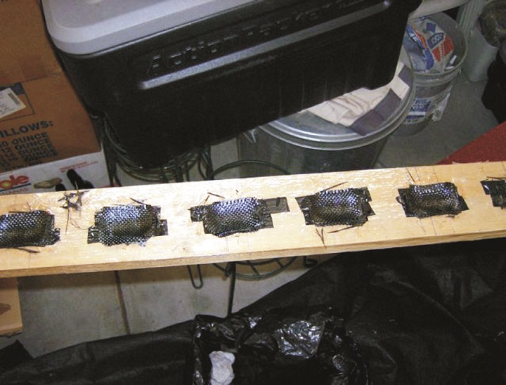 The mold with wet-out carbon fiber. When cured the cups are removed from the mold and trimmed to shape.