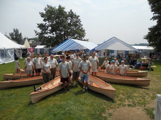 At the end of the three-day Family Build Weekend, the nine family teams pose with their assembled Sassafras 16 canoes. After some additional sanding, coating and finishing these handsome lapstrake canoes will be ready for the water.