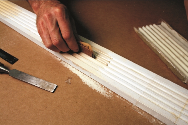 The cast epoxy can be carved with chisels or sanded to match the trim and prepare the surface for paint.