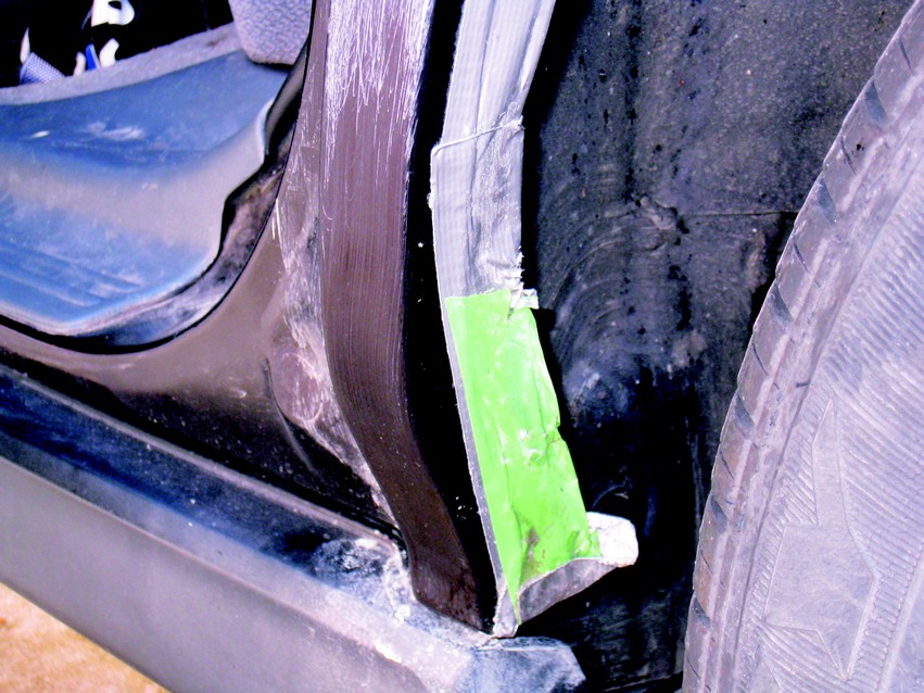 Tape inside the wheel well extends the fender edges to allow for easier removal of the new fiberglass part.