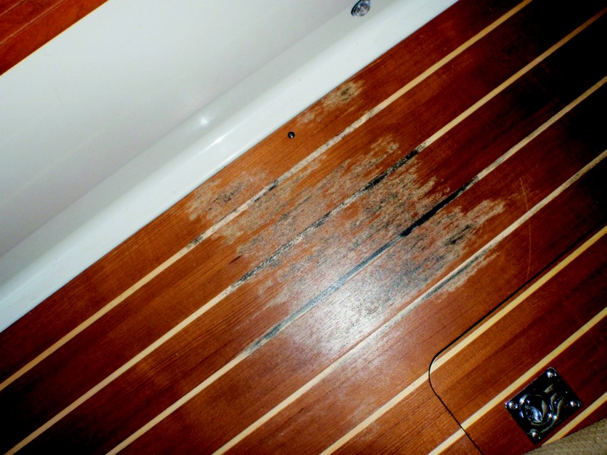 1. Moisture had wicked up through the cabin sole teak/holly plywood. When the floor was removed, moisture was suspended between the sole and cabin sole plate. The cabin sole does not rest on typical floors, rather, it sits in a molded plate with drain holes that proved insufficient for complete draining into the bilge which caused the problem seen in this photo. Additional drain holes were cut before installing the new sole.