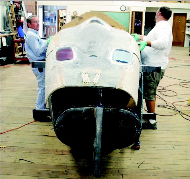 Jan and Greg Bull carefully place the deck skin over the front of STRINGS' fuselage.