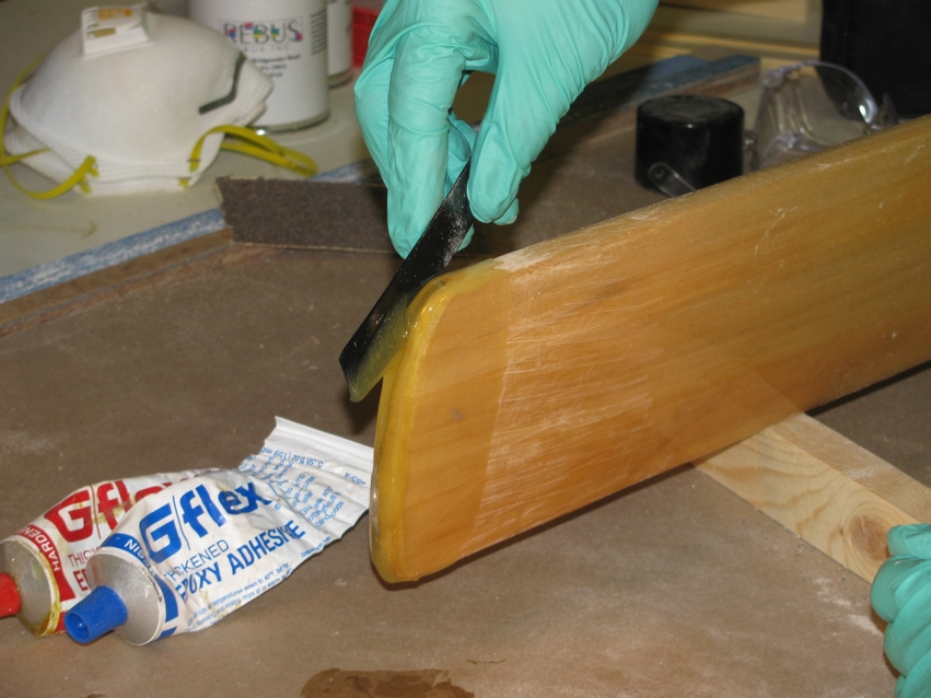 Apply the epoxy to the tip of the wooden paddle from both sides, one side at a time.