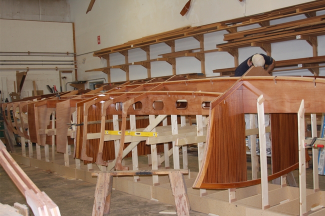 We see here the bulkheads and “girders” installed viewed from the port side. There are two girders (stringers) mounted 1’ off center on both sides. Notice the guy working on the installation – his head is where the keelson will go along the centerline. The frames are removed to install the girders. The permanent bulkheads are also in place.