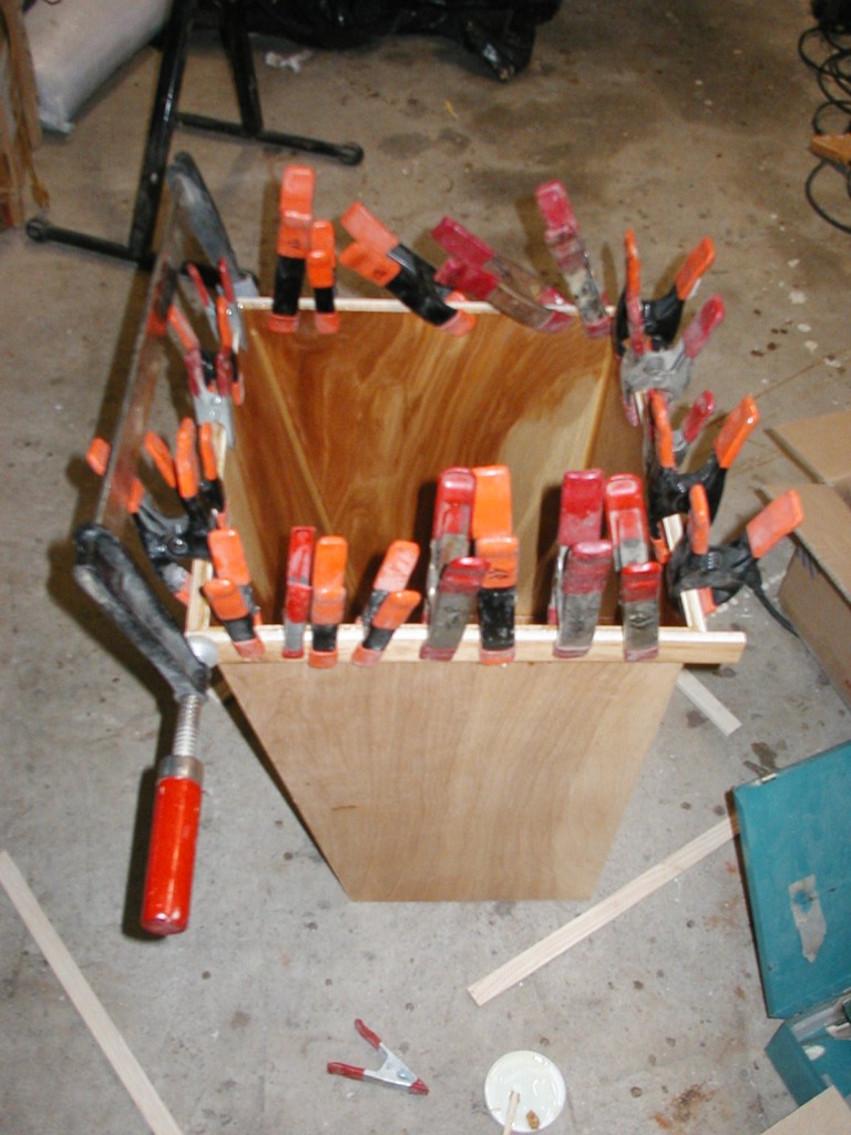 The wooden lip being attached to the wastebasket.