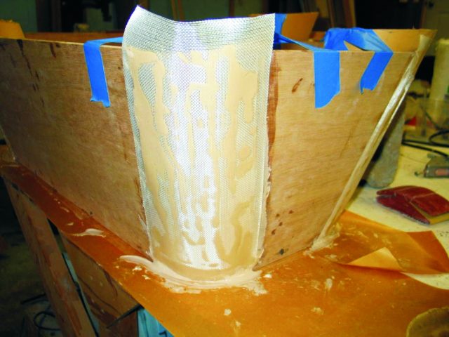 2—The ¼" gap at the edge of the plywood sides was filled with thickened epoxy. A layer of glass tape was laid over the corner and smoothed into the thickened epoxy. The glass was then wet out with epoxy and the edges were sanded smooth when cured.