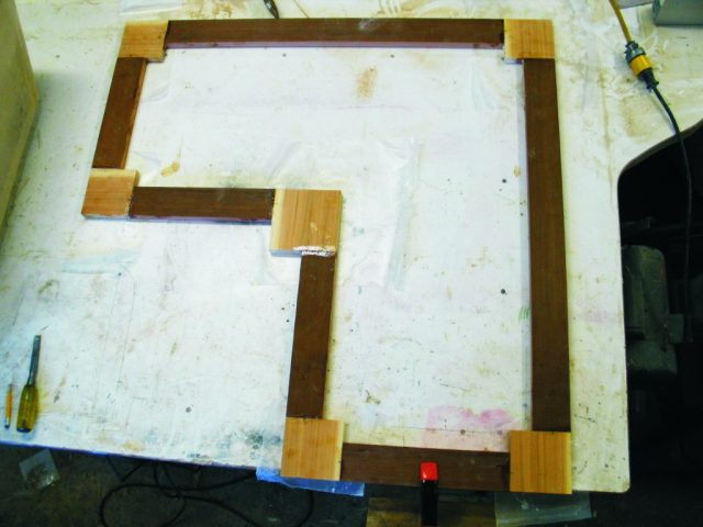 5—The top trim was made from redwood with cedar corners. The square cedar corner blocks were fastened to the end of the redwood strips with biscuits. The blocks were later trimmed to shape and the edges of the entire trim assembly were eased with a round-over bit.