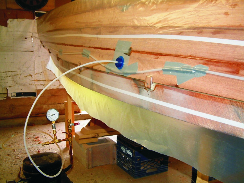 Each ¼" mahogany plank on the hull was clamped using vacuum bagging to avoid staples holes. An old dehumidifier compressor was rigged to pull up to 22" Hg .