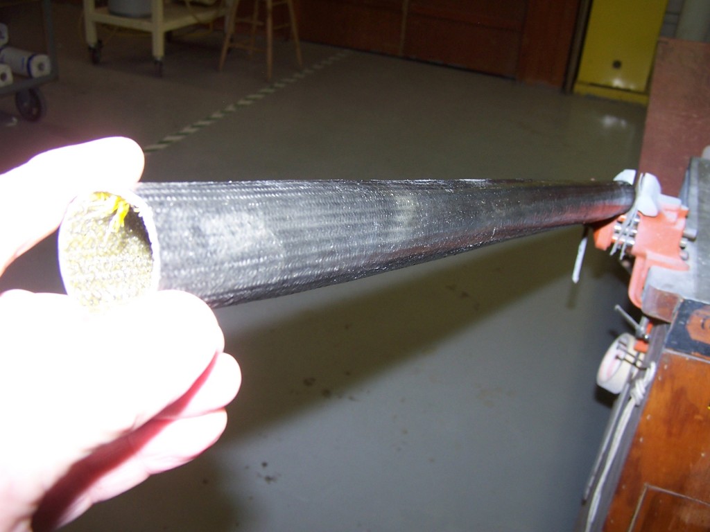 A 6' tube built over a mold of foam pipe insulation. The PET plastic braid that remained is visible inside the carbon fiber tube.
