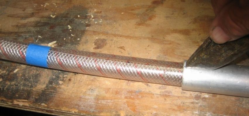 Slice the water hose by drawing it through a tube with a slit for a utility knife.
