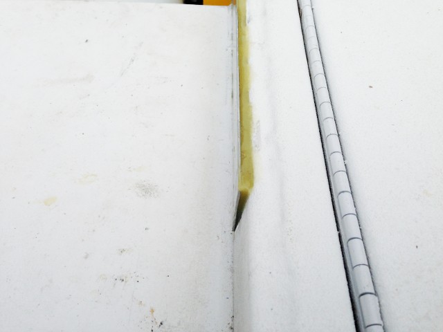 Closeup of tapered gap filled with G/Flex for aluminum hinge repair.
