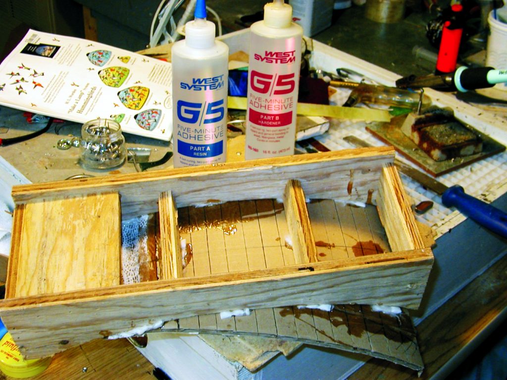 To secure the cardboard to the mold frames I applied G/5 Five-minute adhesive thickened with 403 Microfibers filler along each frame.