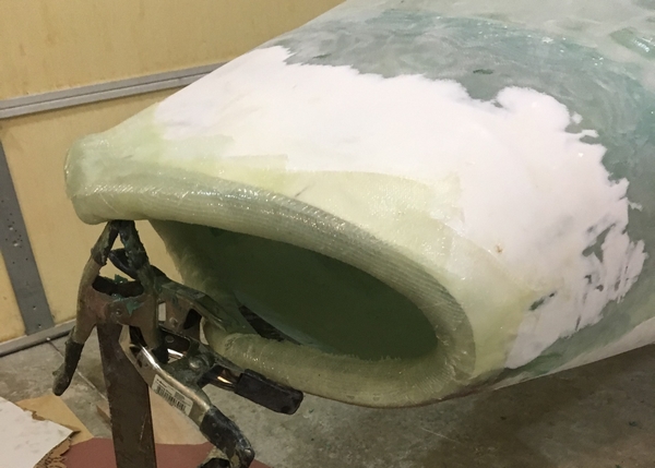 Strips of 10 oz. fiberglass cloth were wrapped halfway over the reinforced hose and attached to the car body. 