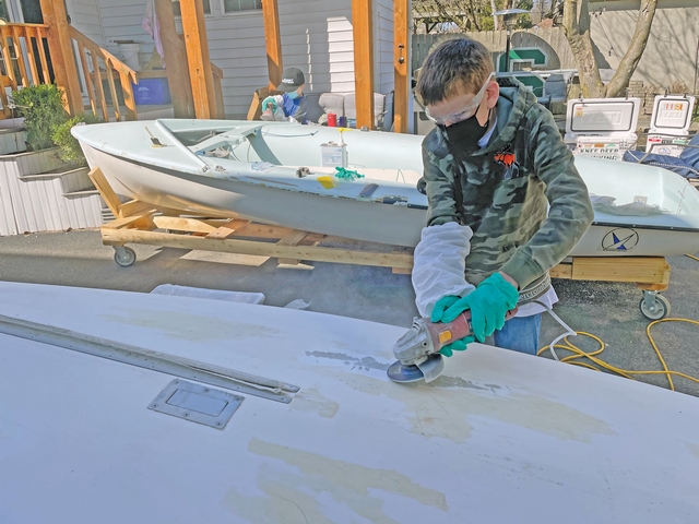 A MKOS team member sanding the Club 420 hull