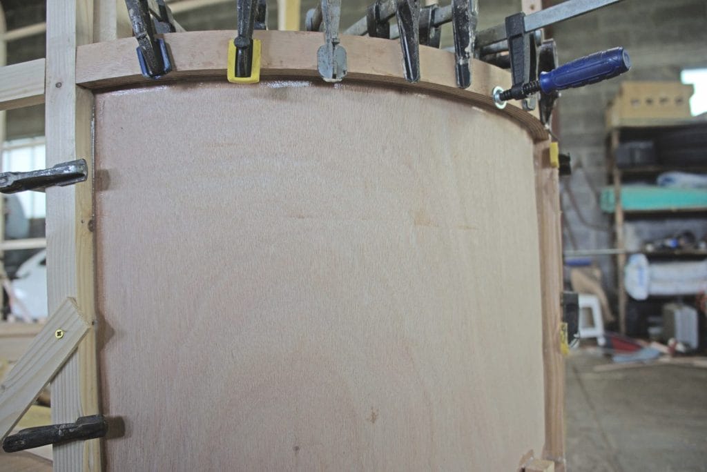 "One of the inner curved panels being epoxied onto the framework." From the article, "The Woodenwidget Plystream Camper" by Robin 'Benjy' Benjamin, featured in Epoxyworks 61.